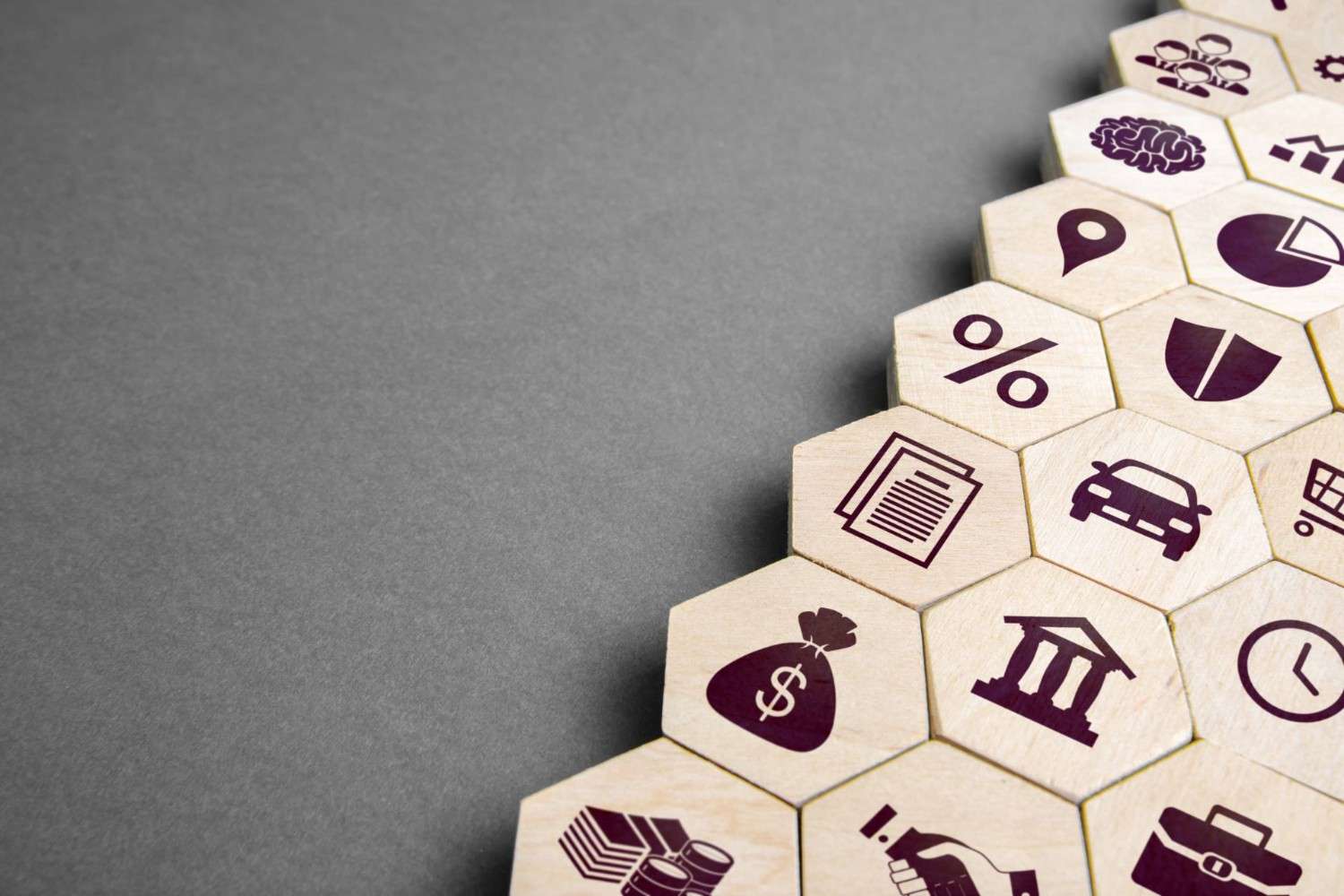Hexagonal tiles featuring various marketing icons on a gray background, symbolizing different attribution models used to measure and optimize marketing channel effectiveness.