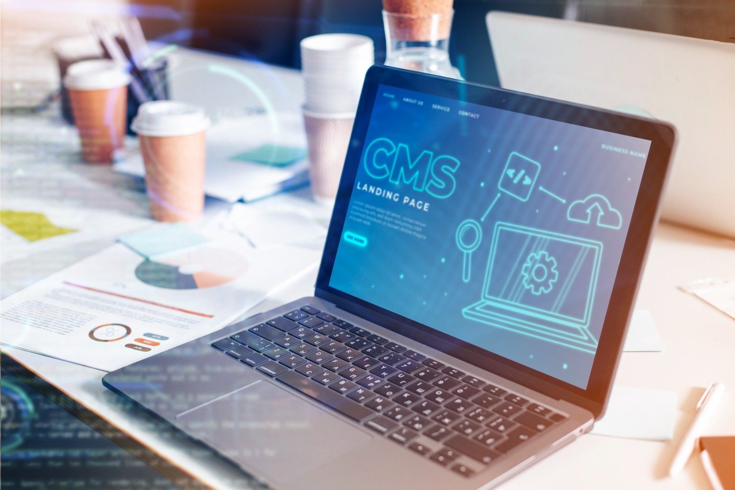 Open laptop displaying CMS landing page on screen, surrounded by office documents and coffee cups, highlighting digital security and content management.